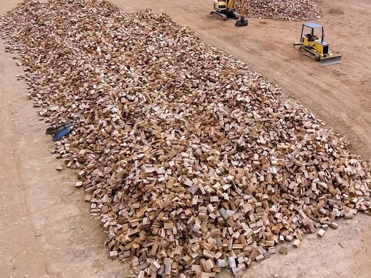 A long pile of freshly split firewood in the Skyline Firewood yard